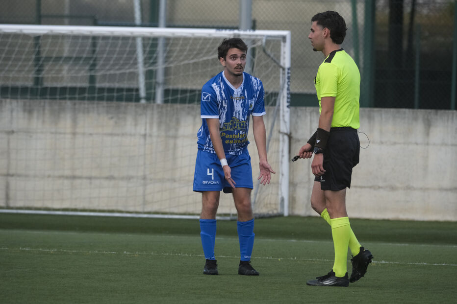 Jogador de futebol discute com o árbitro durante um jogo