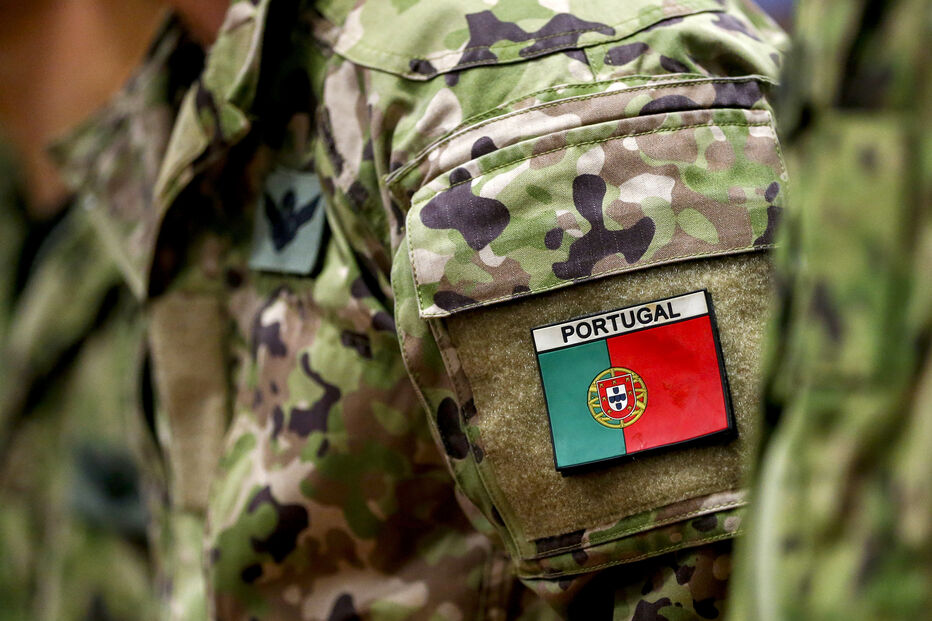 Militar português com farda camuflada e bandeira de Portugal