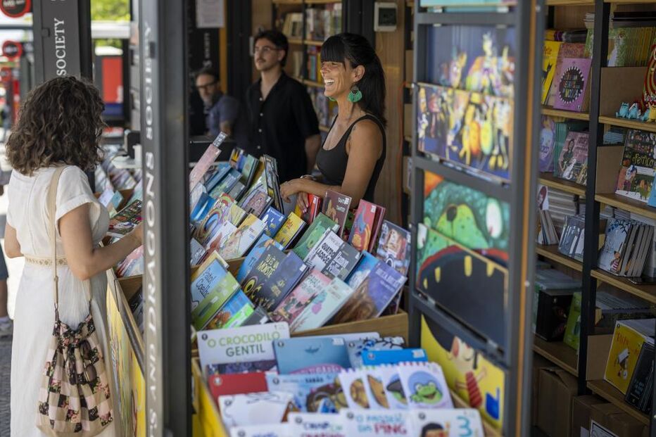 Visitantes exploram livros na Feira do Livro de Lisboa.
