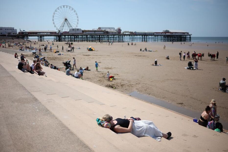 Pessoa deitada nos degraus na estância balnear de Blackpool, Grã-Bretanha