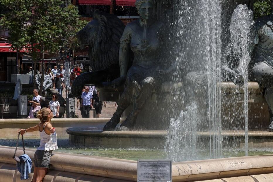 Mulher refresca-se com água de uma fonte em Skopje, República da Macedónia do Norte 