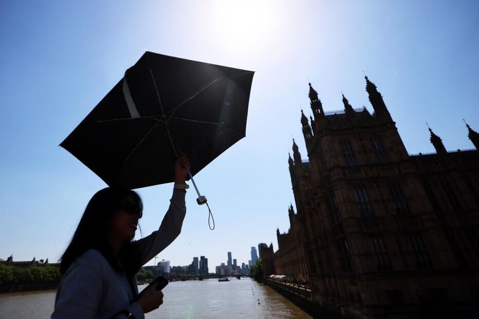 Pessoa protege-se do sol na Ponte de Westminster, em Londres, Reino Unido 
