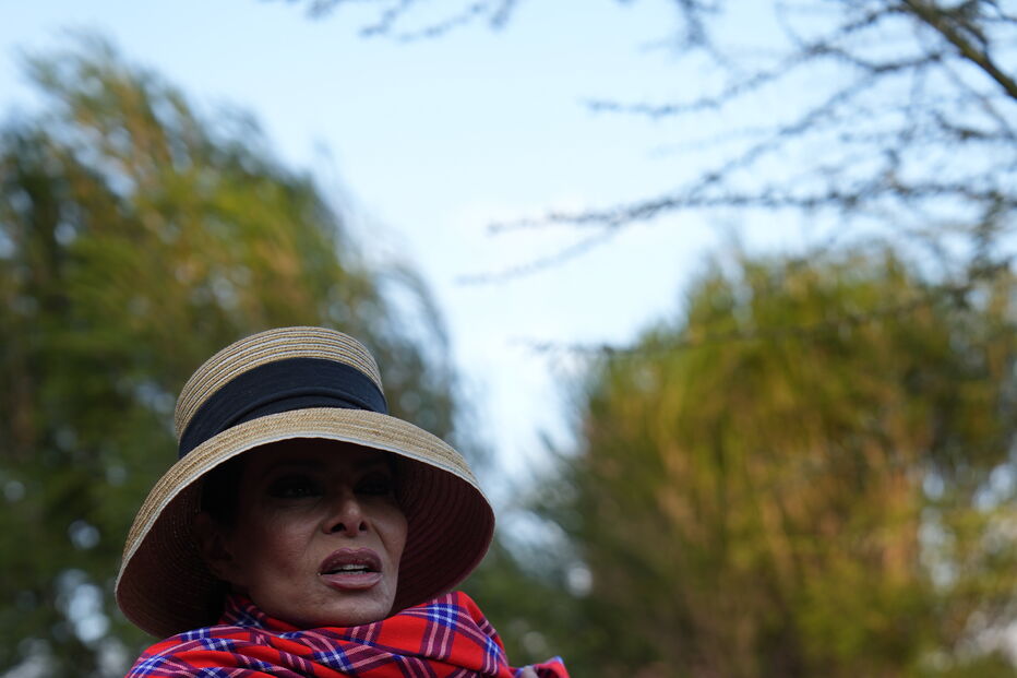 Mulher com vestes tradicionais e chapéu posa para a foto