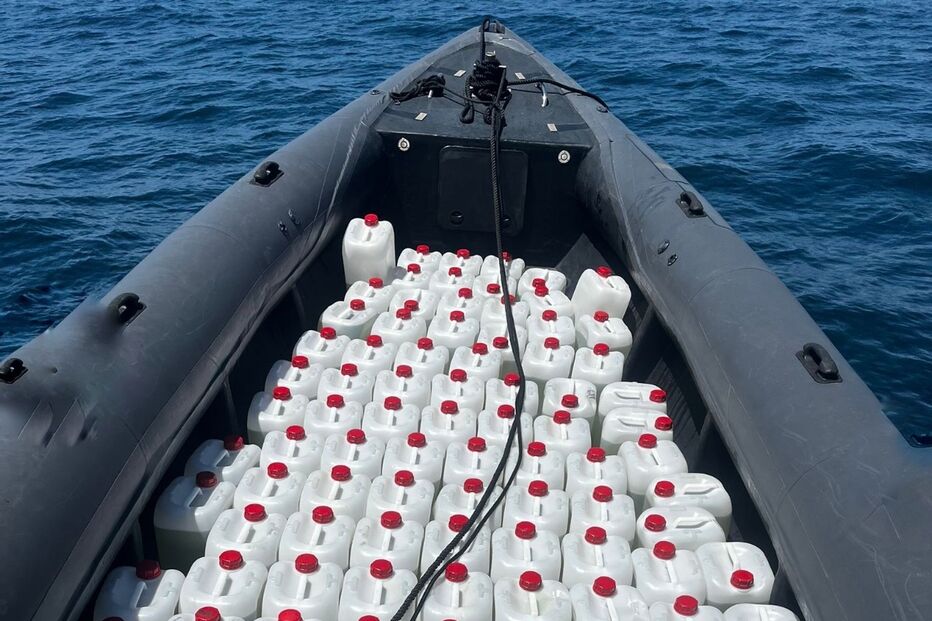 Embarcação com bidões de combustível no mar