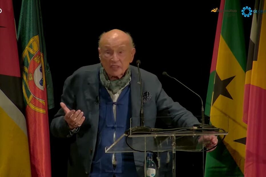 Edgar Morin discursa num evento com bandeiras de vários países