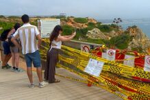 Turistas ignoram sinais de perigo e descem escadas em risco para a praia do Camilo em Lagos