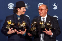 Carlos Santana, à esquerda, e o produtor Clive Davis posam com os seus prémios Grammy na 42.ª cerimónia dos Prémios Grammy, em Los Angeles, a 23 de fevereiro de 2000