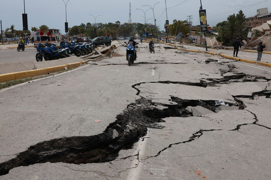 Motociclistas percorrem estrada rachada pelos sismos na Venezuela