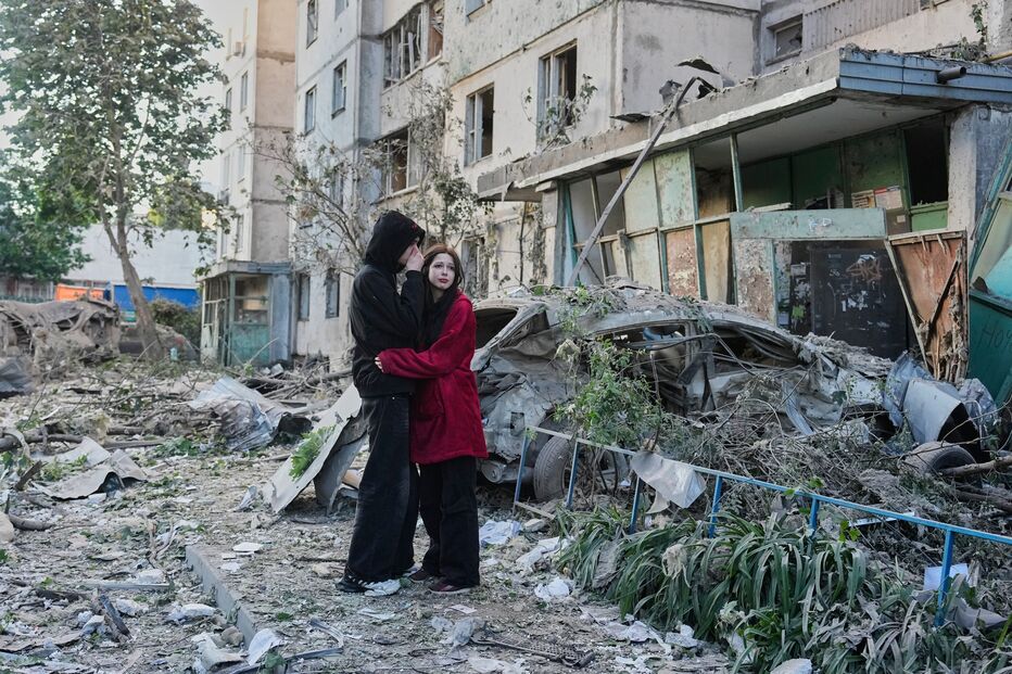As pessoas reagem ao verem o local onde um míssil russo atingiu um edifício residencial em Kiev, na Ucrânia, na terça-feira, 2 de junho de 2026.