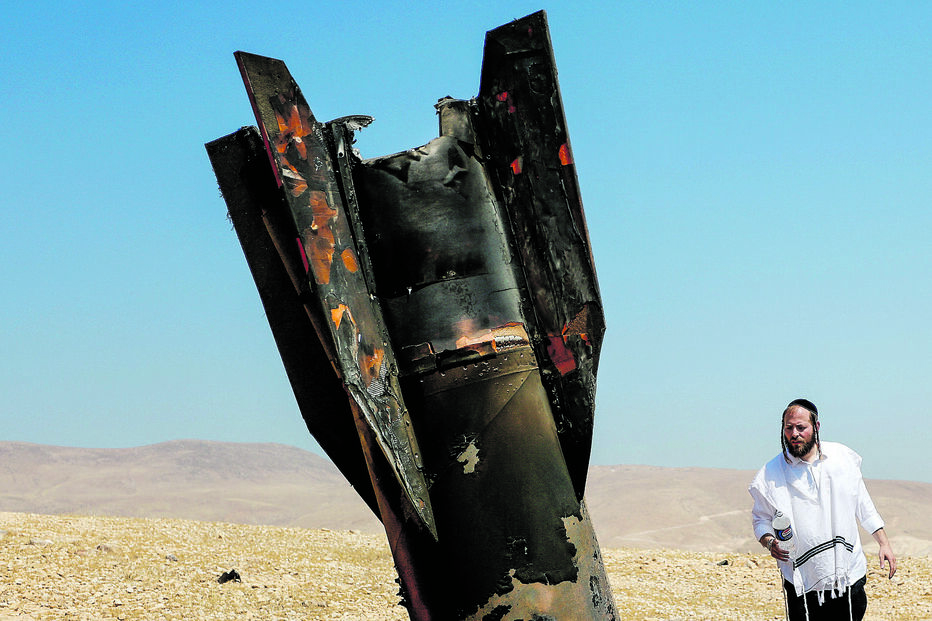 Um judeu ultra-ortodoxo observa os destroços de um míssil balístico iraniano
