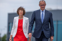O chanceler Friedrich Merz (CDU) e a sua esposa, Charlotte Merz, dirigem-se para o avião no Aeroporto de Berlim-Brandemburgo para voarem para a cimeira da NATO na Turquia