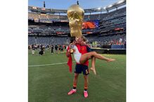 Casal beija-se em campo com troféu da FIFA e medalha de ouro