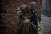 Maggie e Negan caminham juntos numa viela de tijolos