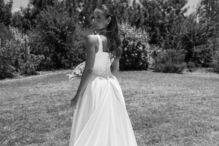 Mulher de vestido branco com véu longo em jardim