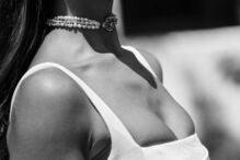 Mulher de top branco e gargantilha de pérolas