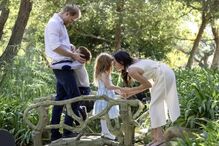 Harry e Meghan com os filhos num jardim