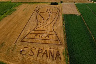 Desenho gigante do troféu do Mundial com FIFA e ESPANA feito em campo em Itália
