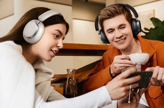 Casal com auscultadores ouve música e vê vídeo no telemóvel