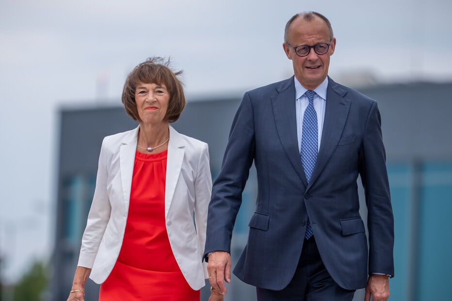 O chanceler Friedrich Merz (CDU) e a sua esposa, Charlotte Merz, dirigem-se para o avião no Aeroporto de Berlim-Brandemburgo para voarem para a cimeira da NATO na Turquia