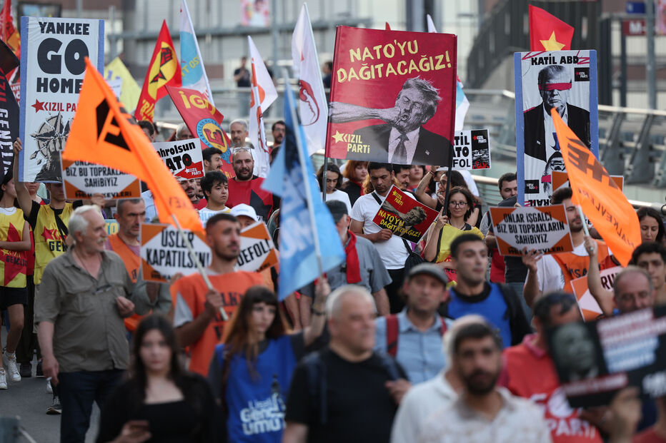 Pessoas marcham durante uma manifestação contra a cimeira da NATO, em Istambul, na Turquia, na terça-feira, 7 de julho de 2026. No cartaz no centro pode ler-se, em turco: «Vamos desmantelar a NATO».