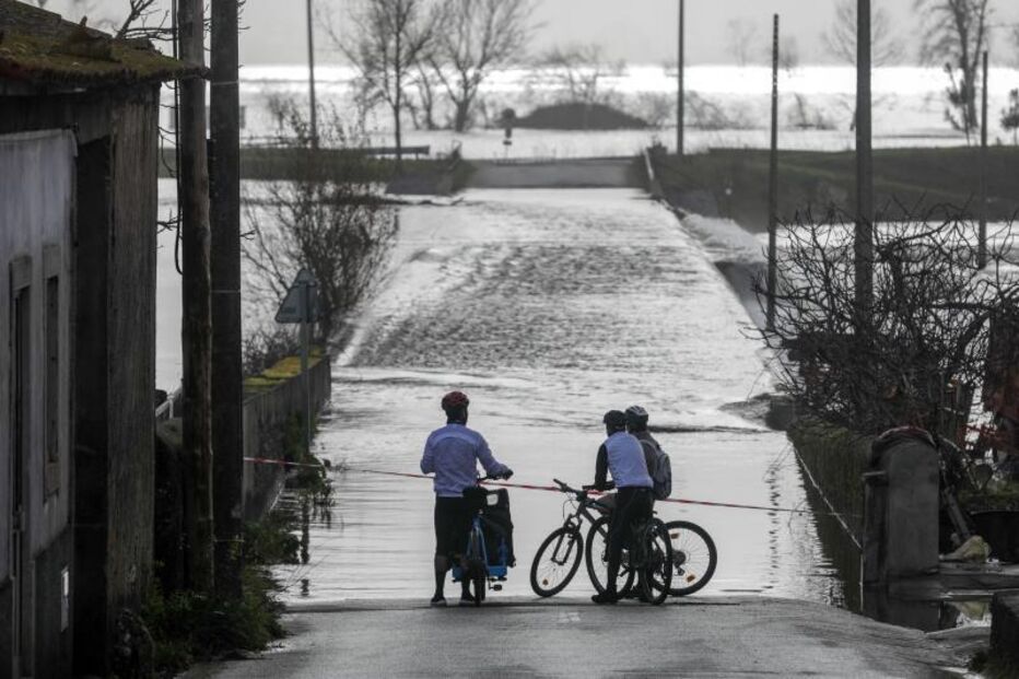 Ciclistas observam estrada submersa perto da barragem de Girabolhos, em contexto de alerta da Quercus