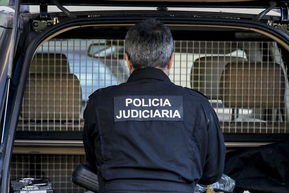 Polícia Judiciária com equipamento policial no porta-malas de um veículo