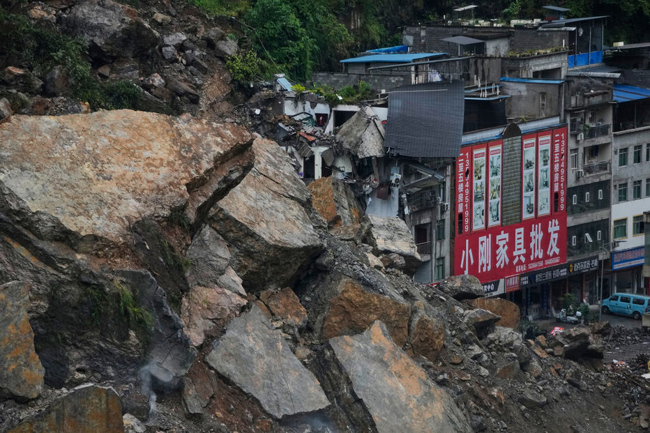 Edifícios residenciais e comerciais danificados pela queda de rochas e lama são visíveis após um deslizamento de terra no condado de Pengshui, em Chongqing, no sudoeste da China, no sábado, 18 de julho de 2026