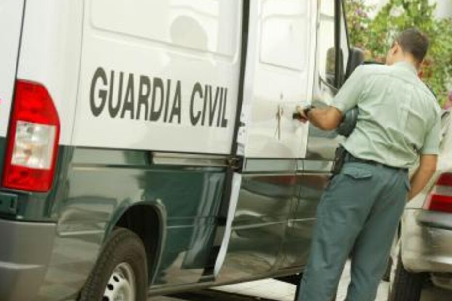 Um agente da Guarda Civil abre a porta de uma carrincha verde e branca