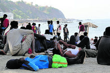 Migrantes esperam junto ao mar na costa de Espanha