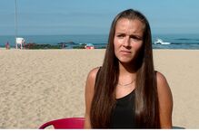 Mulher na praia preocupada com agência de viagens que lesou mais de cem pessoas