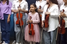 Grupo de crianças e jovens com violinos