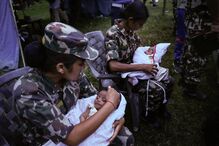 Miliatares do exército nepalês com dois bebés gémeos durante operação de resgate