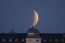 A partial lunar eclipse is visible over the Halic Castle,