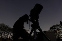 People observe the partial lunar eclipse as seen over a