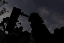 People observe the partial lunar eclipse as seen over a