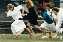  A princesa Diana, do Reino Unido, vestida com um vestido branco, corre à frente durante a corrida das mães, realizada no âmbito de um dia desportivo da escola de Wetherby, onde o seu filho, o príncipe William, é aluno, na terça-feira, 28 de junho de 1989