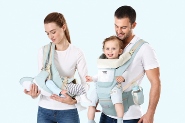 Casal com bebés em porta-bebés ergonómicos, apresentando conforto e segurança