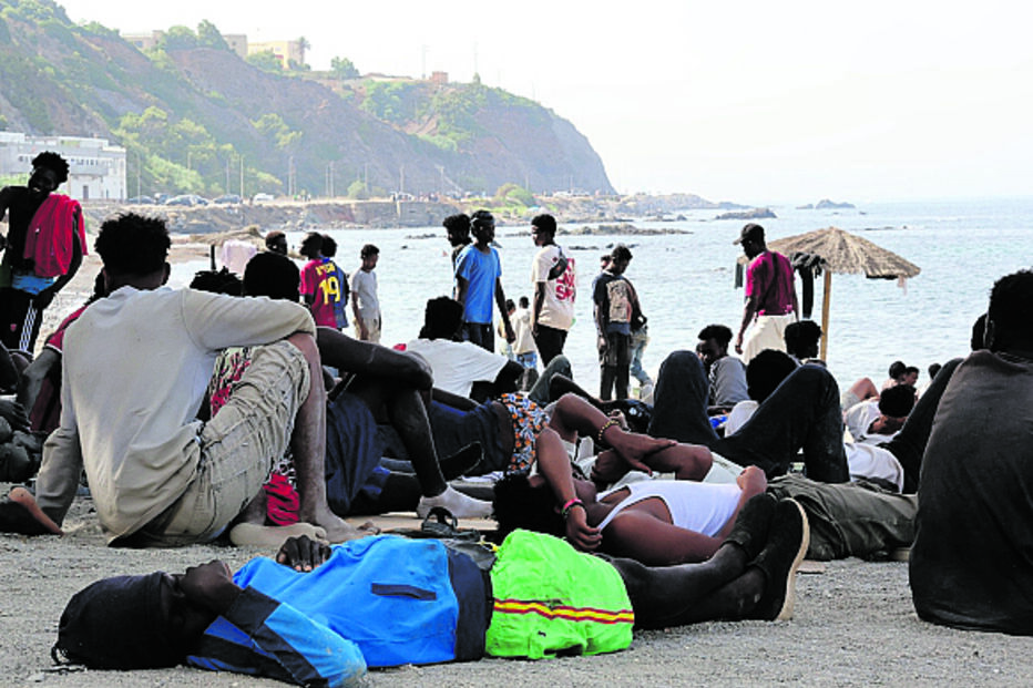 Migrantes esperam junto ao mar na costa de Espanha