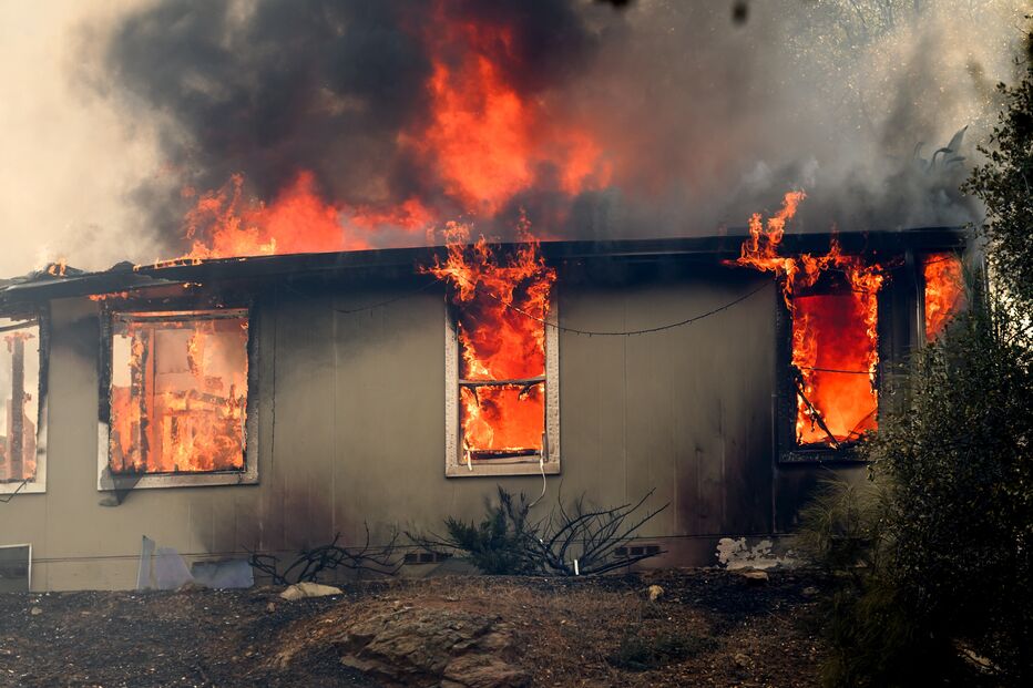 Casa em chamas com fumo negro e nuvens de fogo
