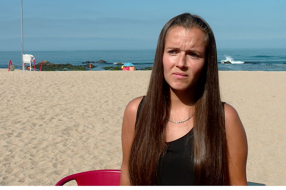 Mulher na praia preocupada com agência de viagens que lesou mais de cem pessoas