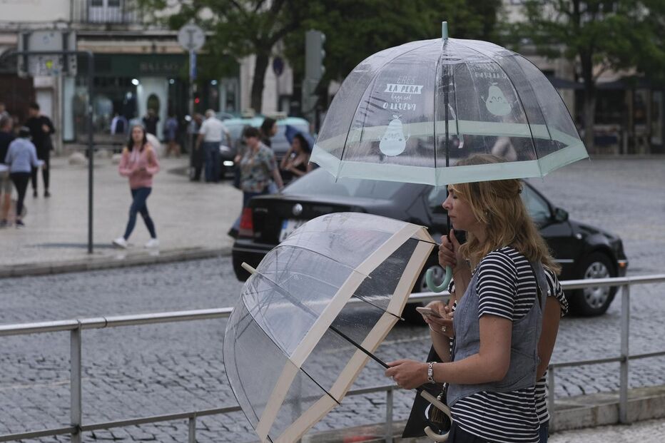 Mulheres com guarda-chuvas em Lisboa aguardam chuva prevista para o fim de semana