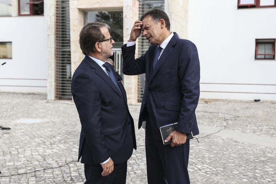 O primeiro-ministro, Luís Montenegro (D), conversa com o ministro da