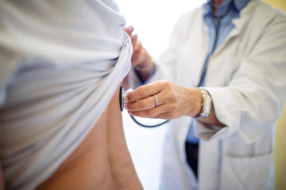 Médico examina paciente com estetoscópio em centro de consultas para atestados médicos