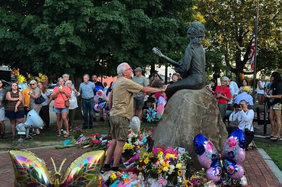 Homenagem a Dolly Parton, um anjo na terra, com flores e balões em frente à sua estátua