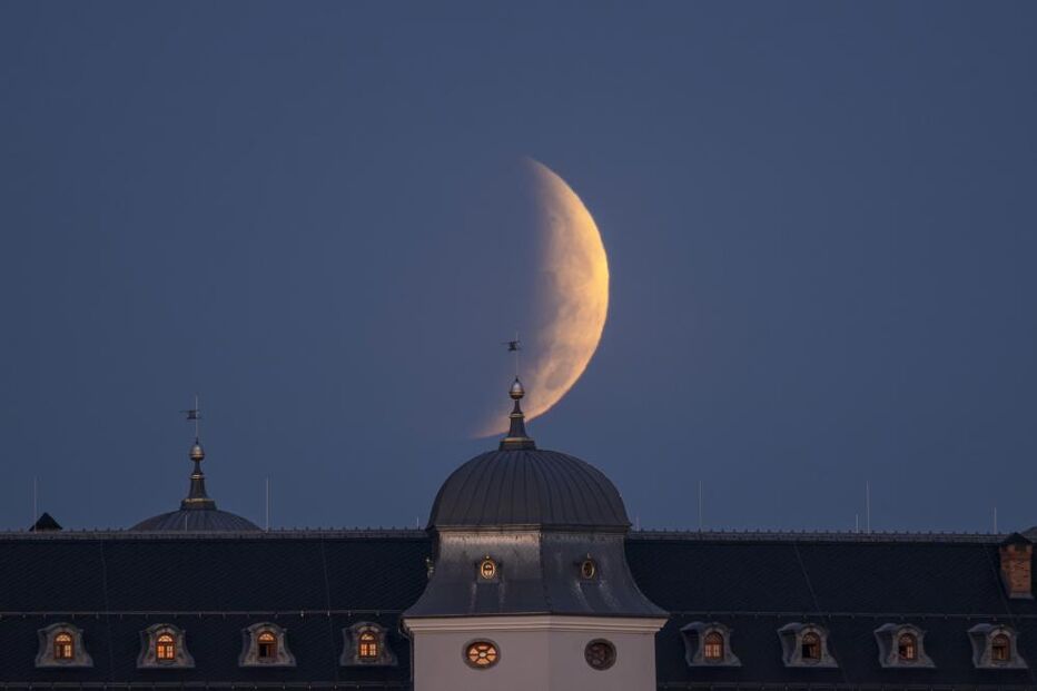 A partial lunar eclipse is visible over the Halic Castle,