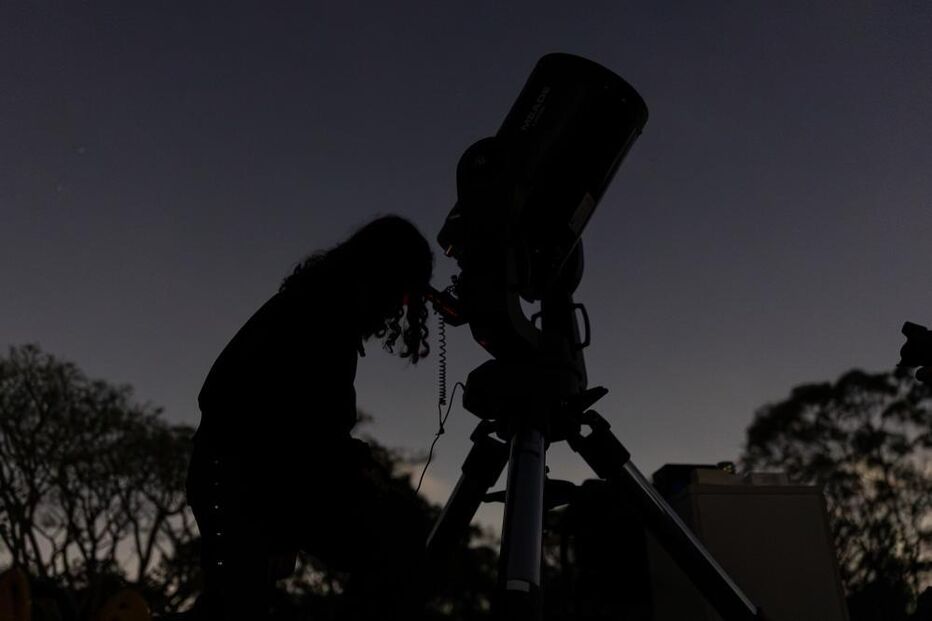 People observe the partial lunar eclipse as seen over a