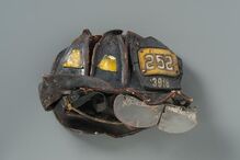 Capacete do bombeiro Kevin M. Prior, da Squad 252. Foi recuperado nos escombros severamente esmagado, com o visor separado e o couro deformado. O corpo de Prior só foi recuperado três semanas depois.   A mãe, Marian, queria desesperadamente recuperar o capacete. Acabou por descobrir onde estava depois de aparecer num programa de televisão. 
