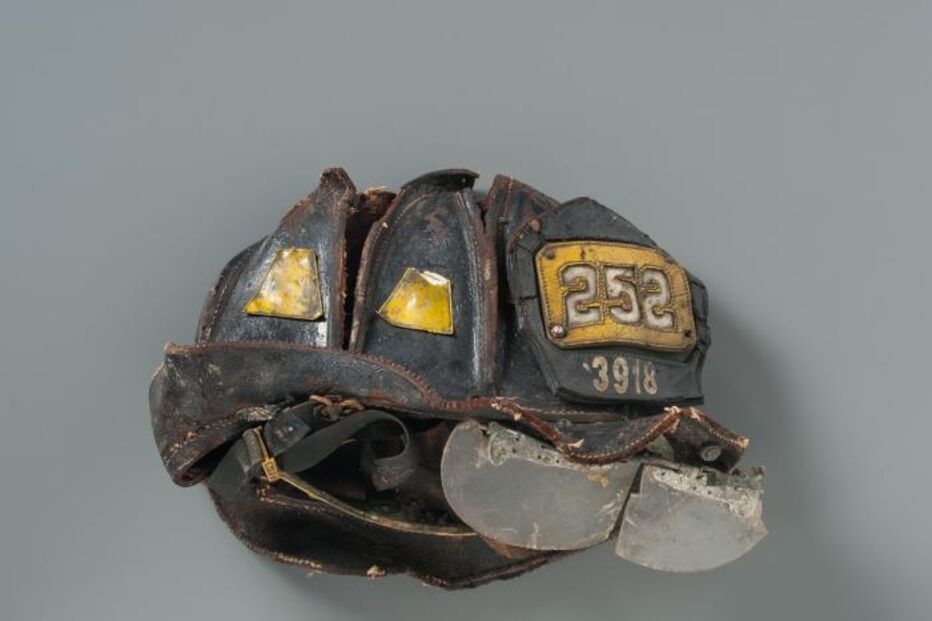 Capacete do bombeiro Kevin M. Prior, da Squad 252. Foi recuperado nos escombros severamente esmagado, com o visor separado e o couro deformado. O corpo de Prior só foi recuperado três semanas depois.   A mãe, Marian, queria desesperadamente recuperar o capacete. Acabou por descobrir onde estava depois de aparecer num programa de televisão. 