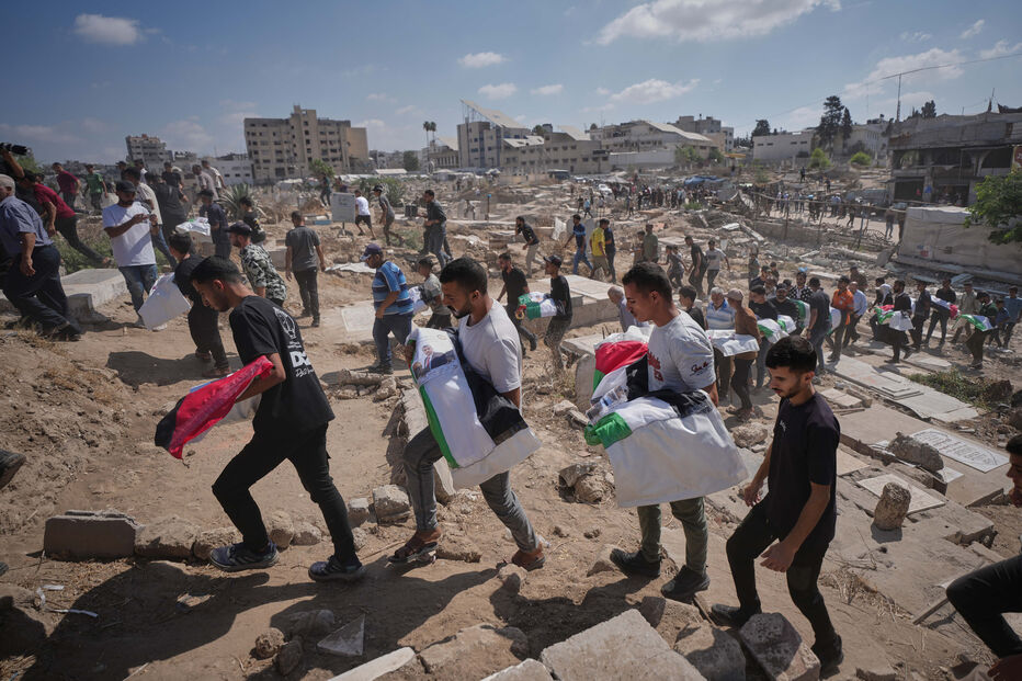 Gaza. Homens transportam corpos cobertos com bandeiras palestinianas em Gaza
