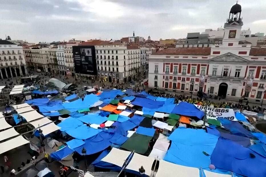 Manifestantes acampam na Puerta del Sol, em Madrid, com tendas azuis e brancas